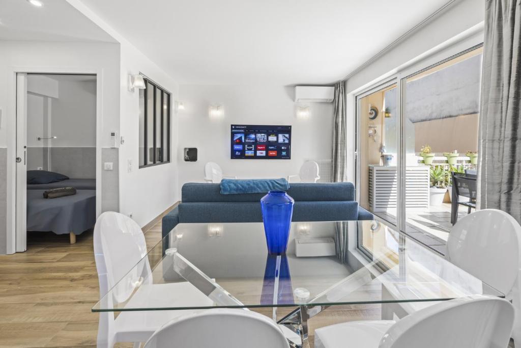 a glass table with a blue vase on it in a room at Cannes NG - Appartement à 10 mn du Palais des Festivals in Cannes