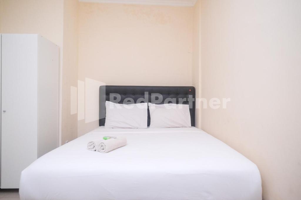 a bedroom with a white bed with white pillows at Griya Loka 2 Syariah Near Simpang Lima Mitra Reddoorz in Semarang