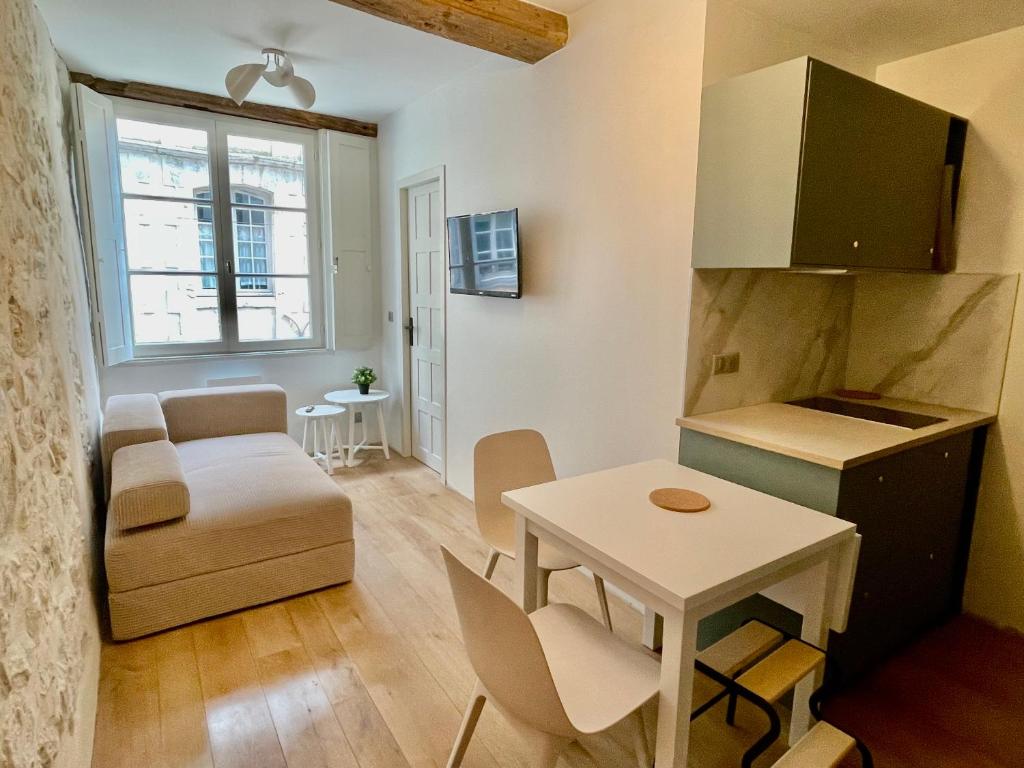 uma pequena sala de estar com uma mesa e um sofá em Appartement hyper centre 2 chambres em Baiona