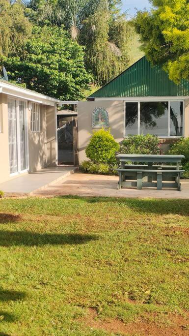 a park bench sitting in front of a building at Serenity Alpaca Self Catering Cottage in Lions River