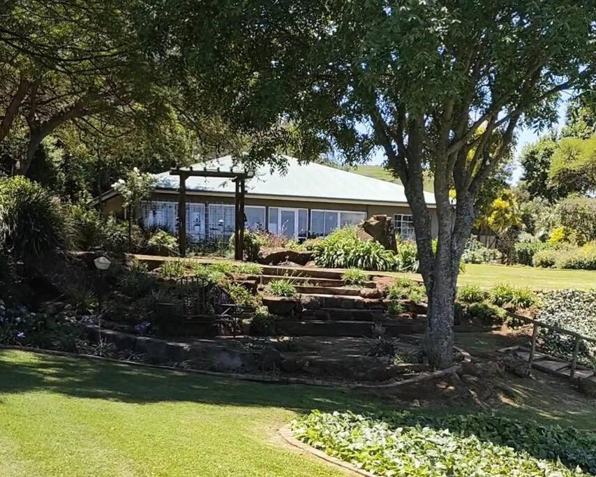 a garden with a building in the background at Serenity Alpaca Guest Farm in Lions River