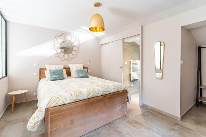 a bedroom with a large bed with blue pillows at LE MAZET DES CHUTES in Graveson