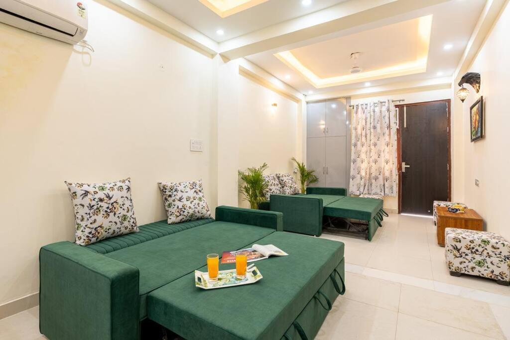 a living room with green couches and tables at Homlee-Vasundhara 5BHK with Terrace(For Function) in Ghaziabad