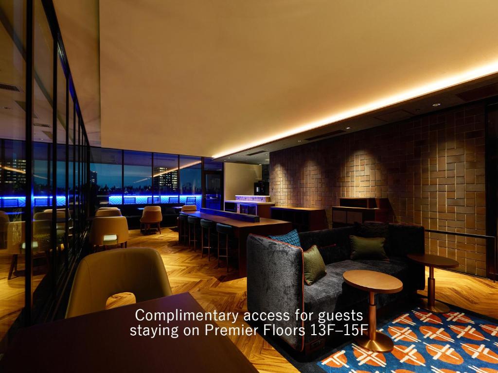a lobby with a couch and a bar at Mitsui Garden Hotel Osaka Premier in Osaka