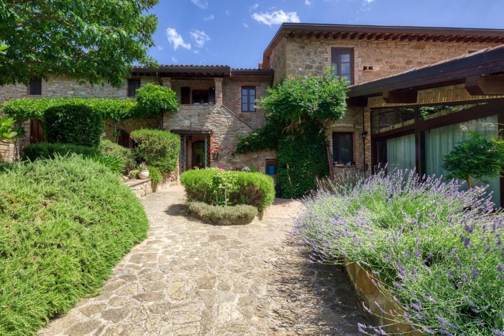 une maison en pierre avec un jardin en face dans l'établissement Le Terre Di Isa, à Magione