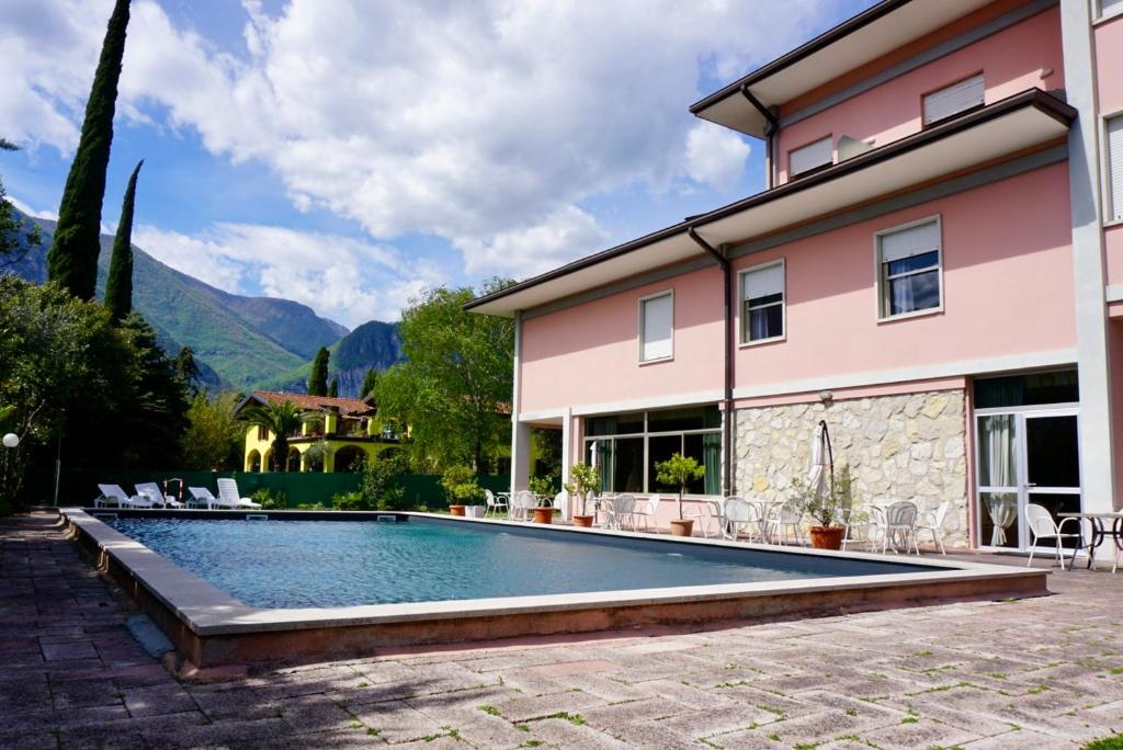 a swimming pool in front of a house at Hotel Diana in Riva del Garda