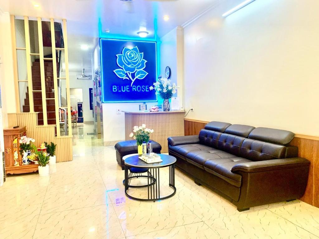 a lobby with a leather couch and a table at Blue Rose Hotel in Ha Long