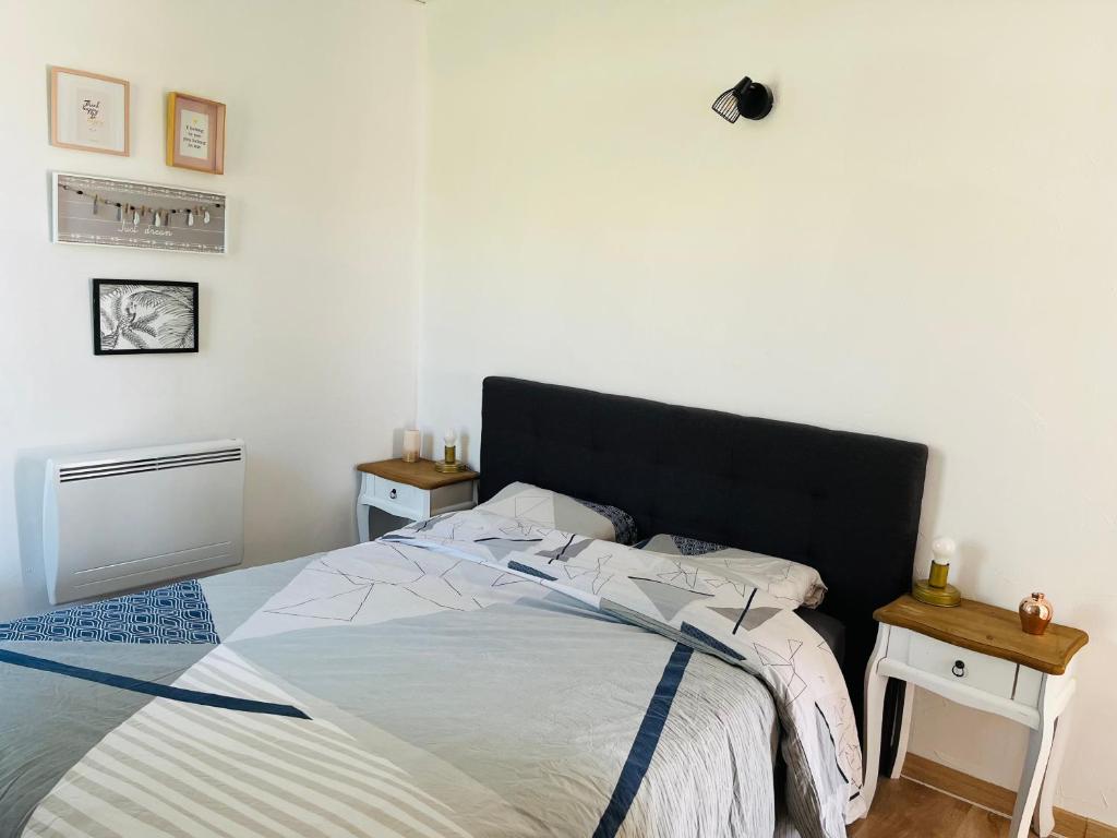 a bedroom with a bed with a black headboard at Charmante maisonnette 4pers in Canet