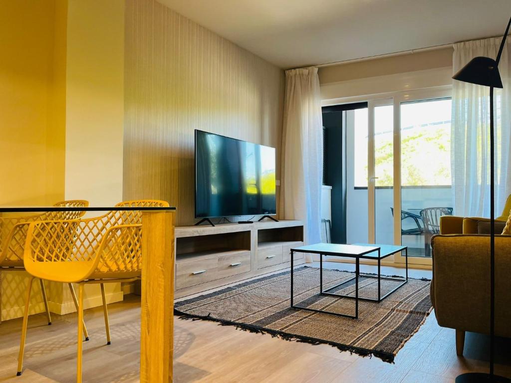 sala de estar con TV y mesa en Wellingtonia Lujoso apart con piscina y parking en Estepona