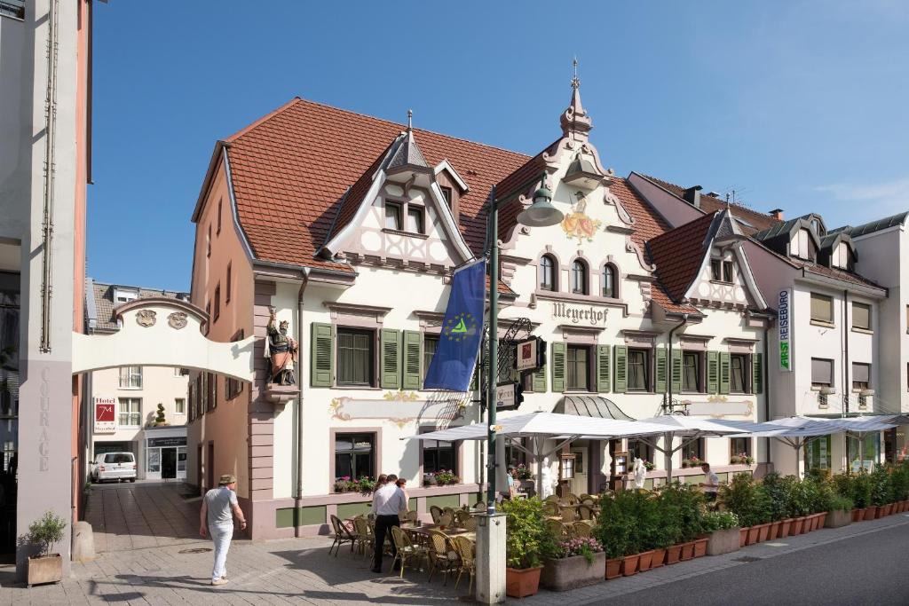 a building with people walking in front of it at Hotel Meyerhof in Lörrach