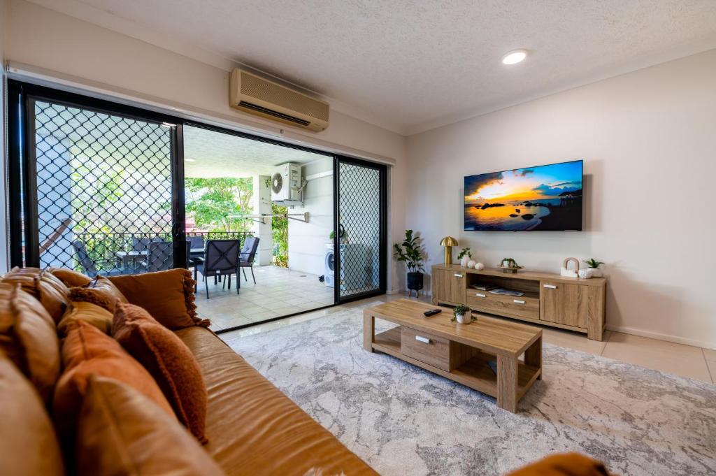 a living room with a couch and a table at Deluxe 2-Bed Unit with Parking and Outdoor Area in Brisbane