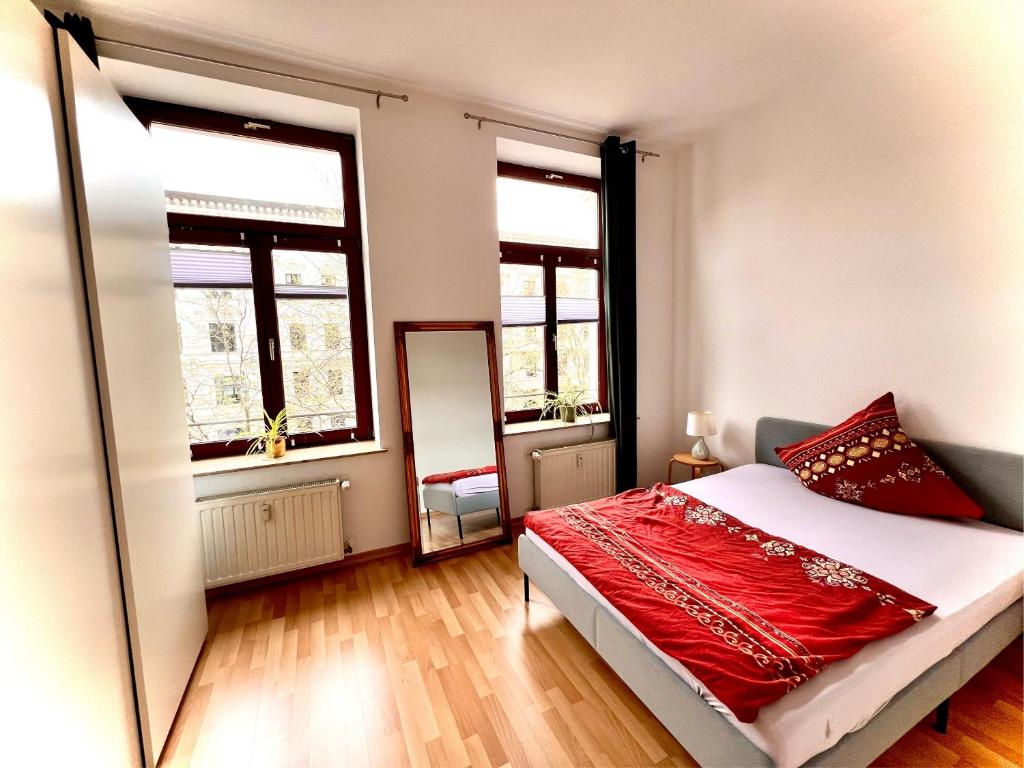 Schlafzimmer mit einem Bett, einem Spiegel und Fenstern in der Unterkunft Hegelstraße, Prachtstraße der Gründerzeit in Magdeburg