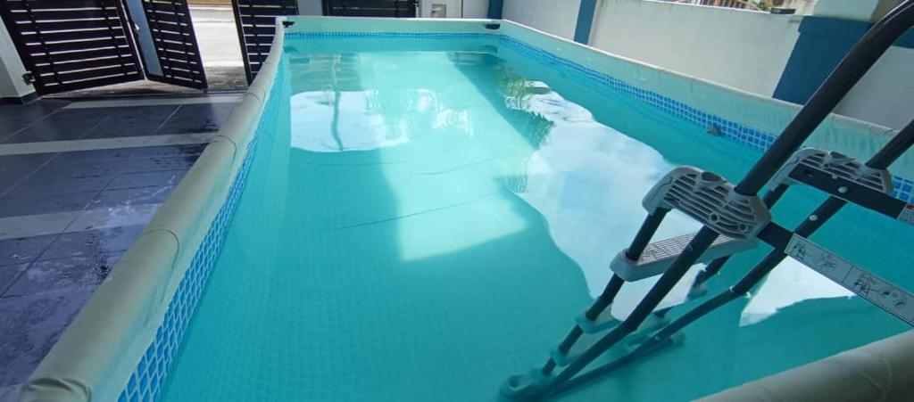 Chemor的住宿－PRIVATE POOL Ssue Klebang Ipoh Homestay-Guesthouse With Wifi & Netflix，一个空的游泳池,里面摆放着两把椅子