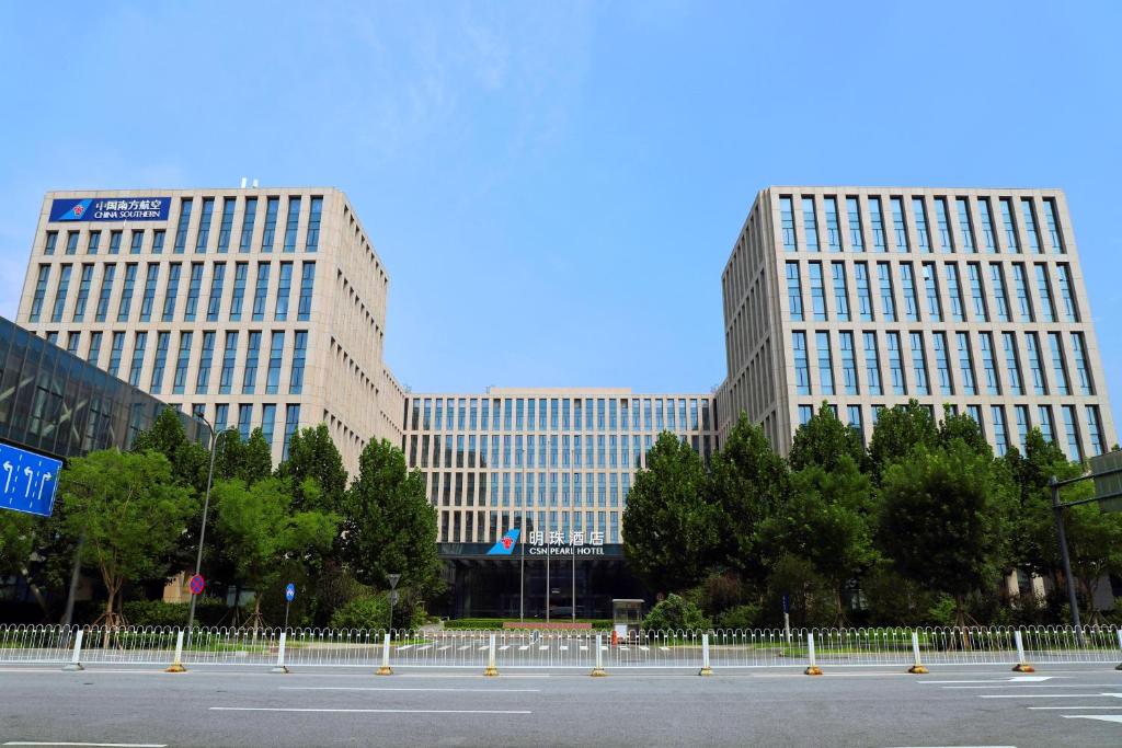 deux grands bâtiments devant un parking dans l'établissement Beijing CSN Pearl Hotel, à Pékin