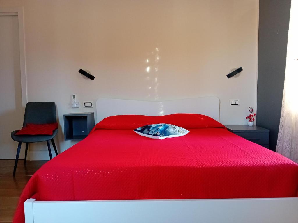 1 cama roja con edredón rojo y almohada en Come nelle Favole, camere e appartamenti en Castellabate