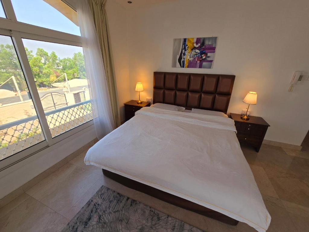 a bedroom with a large bed and a large window at Stay House in Dubai in Dubai