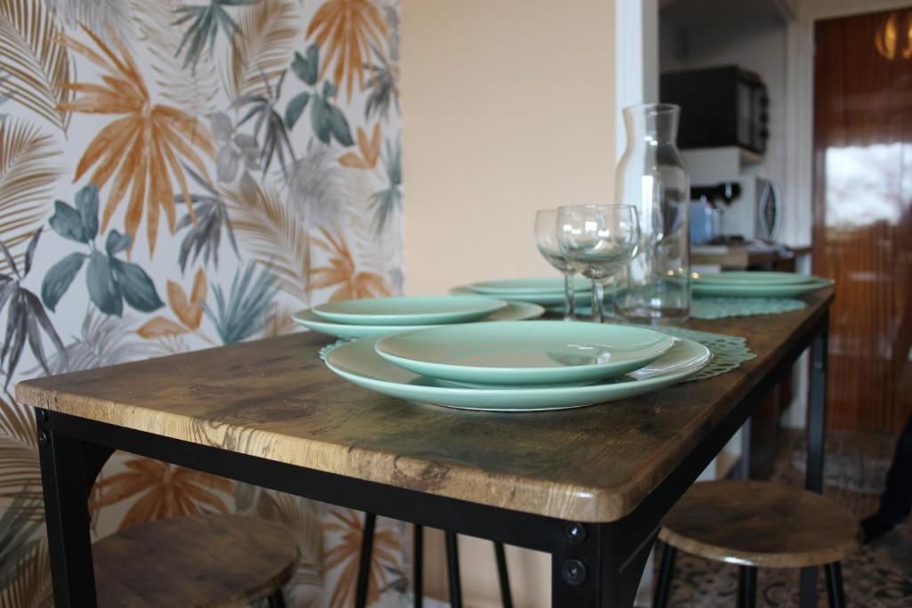 - une table en bois avec des assiettes et des verres à vin dans l'établissement Studio Le Cosy, à Montrichard