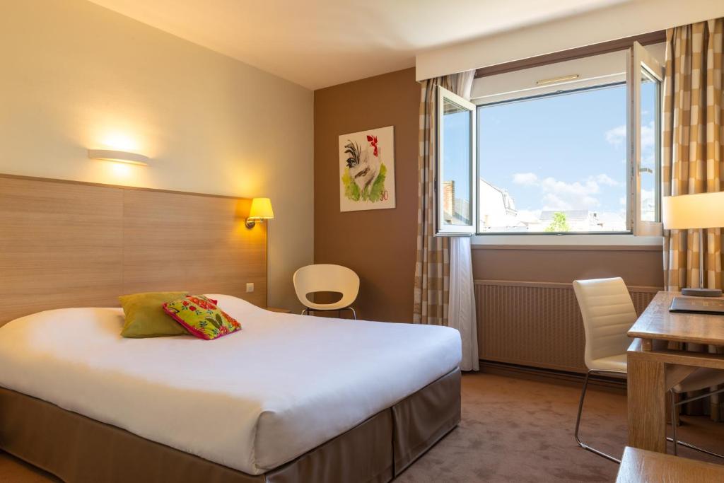 une chambre d'hôtel avec un lit et une fenêtre dans l'établissement The Originals City, Hôtel Chantecler, Le Mans, au Mans