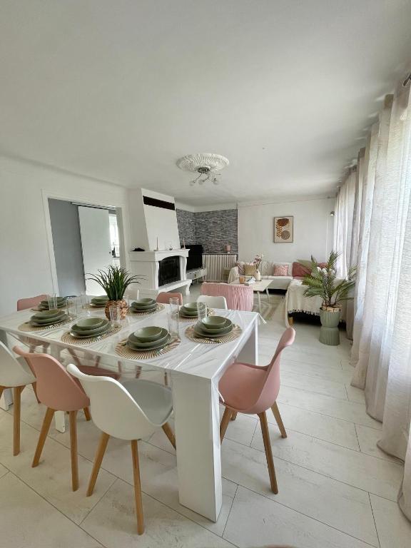 a white dining room with a table and chairs at Maison chaleureuse 4 chambres avec jardin - Proche Paris - ARENA Paris Nord Villepinte - Parc des expositions - Aéroport CDG - Disney - Astérix in Tremblay En France