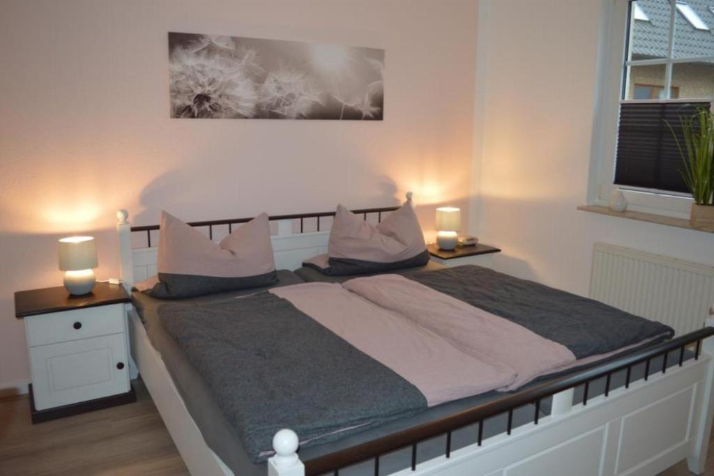 1 dormitorio con 1 cama grande y 2 mesitas de noche en 7 EG - Charmante Ferienwohnung mit Seeblick & schoenem Garten in Röbel an der Müritz, en Marienfelde