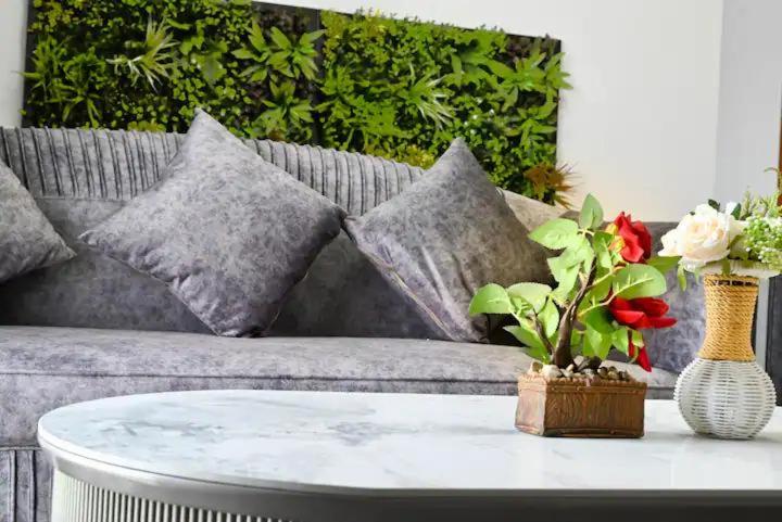 - un salon avec un canapé et une table fleurie dans l'établissement Al Wahid Holiday Homes, à Dubaï