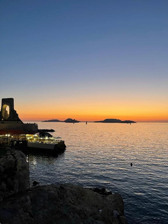 a sunset over a body of water with a dock at Appartement + terrasse à 5min à pied de la mer et du Vallon des auffes in Marseille