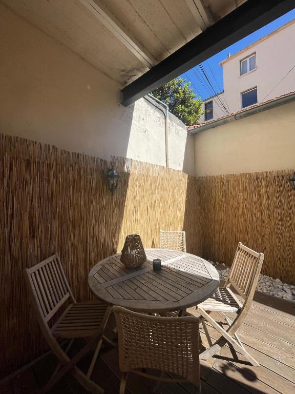 a patio with a table and chairs and a fence at Appartement + terrasse à 5min à pied de la mer et du Vallon des auffes in Marseille
