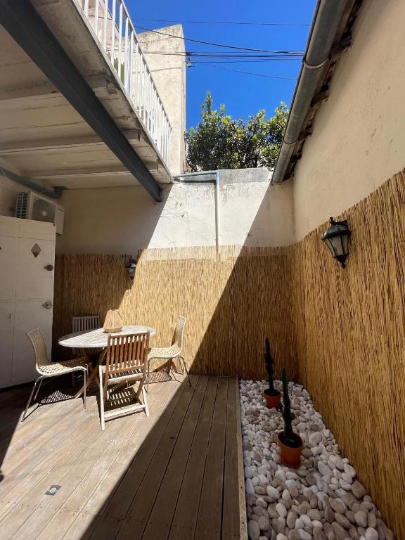 a patio with a table and chairs on a wooden deck at Appartement + terrasse à 5min à pied de la mer et du Vallon des auffes in Marseille