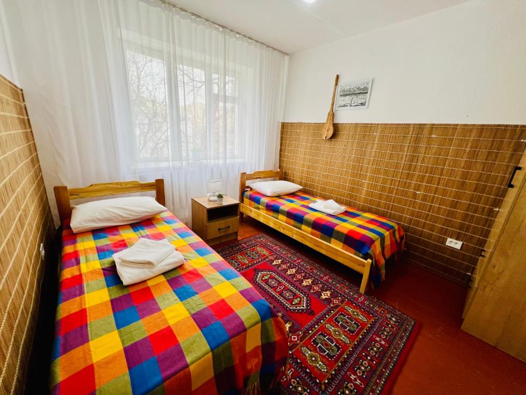 Naryn的住宿－Dadow Cozy House，客房设有两张床和窗户。