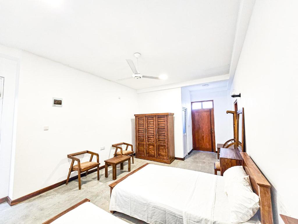 a bedroom with a bed and a table and chairs at The Hostel in Gampaha