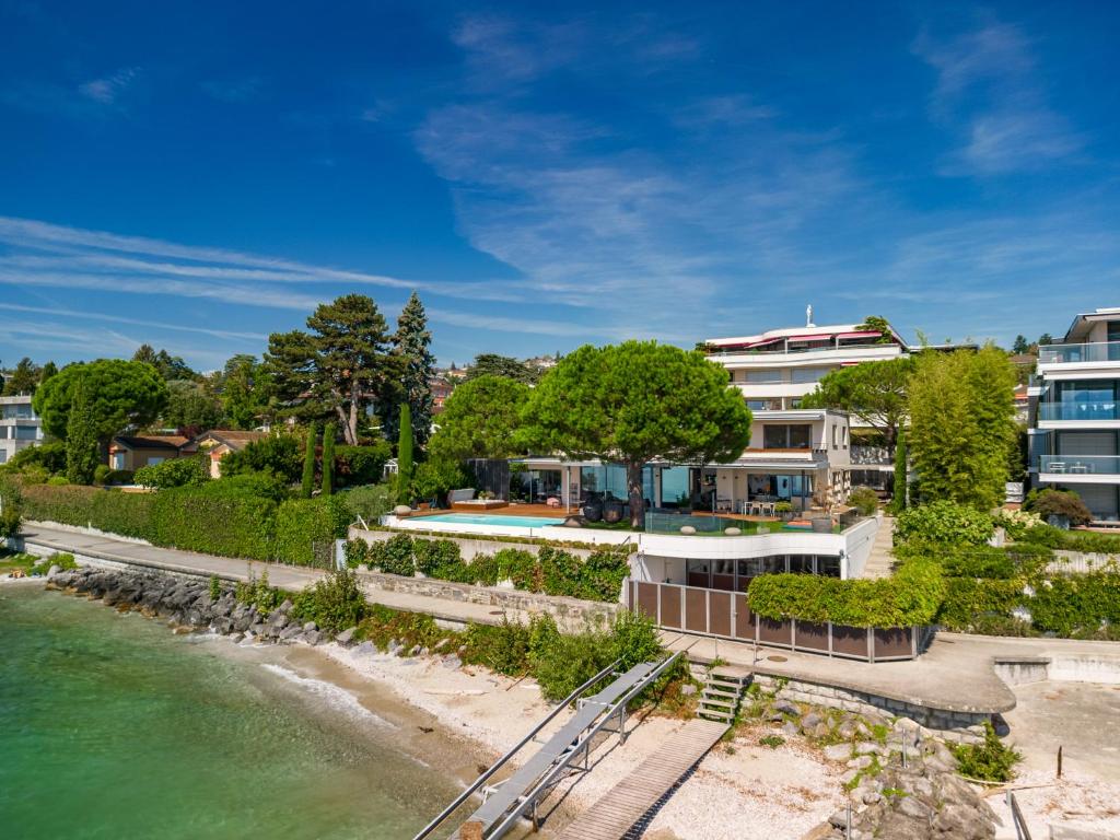 una vista aerea di un edificio accanto a una cassa d'acqua di Lausanne area Luxurious 4-Bedroom Villa on the Lake by GuestLee a Pully