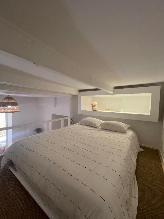 a bedroom with a white bed with a window at Appartement + terrasse à 5min à pied de la mer et du Vallon des auffes in Marseille