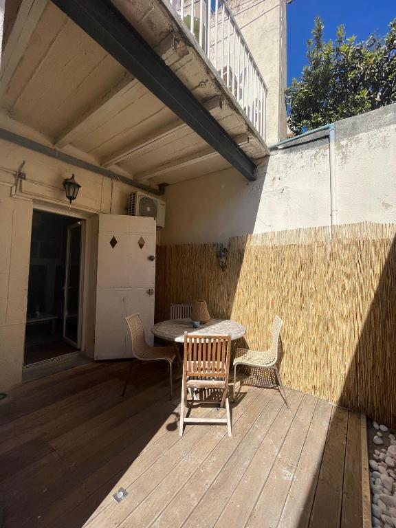 a patio with a table and chairs on a deck at Appartement + terrasse à 5min à pied de la mer et du Vallon des auffes in Marseille