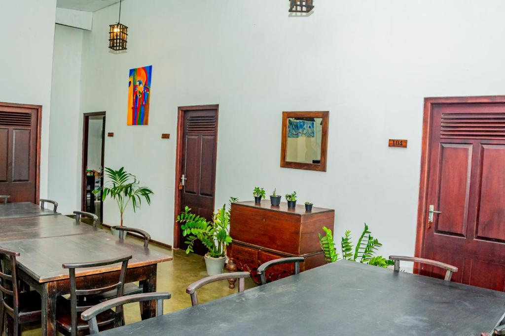 a dining room with tables and chairs and a door at ShiCo Transit Hotel in Negombo