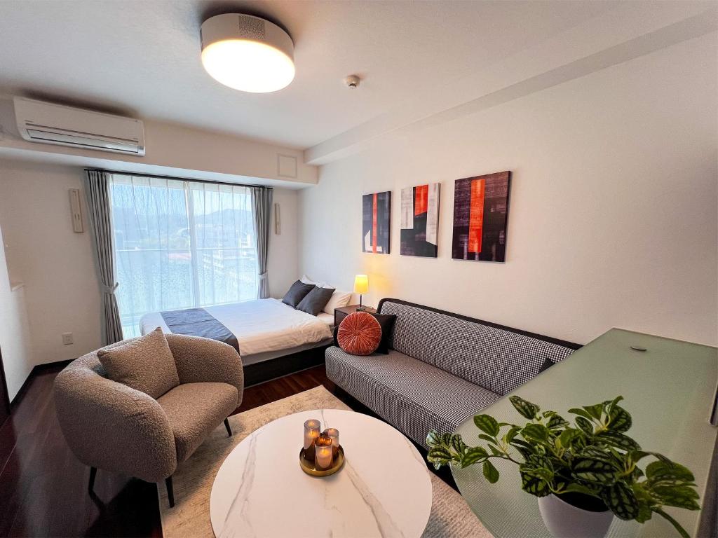 a living room with a couch and a bed at OUCHI HOTEL Hatchobori in Hiroshima