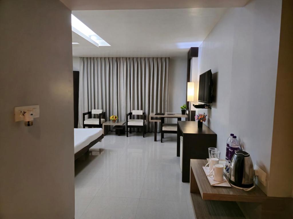 Habitación de hotel con zona de comedor y sala de estar. en Hotel Daaysco Oley Allo, en Guwahati