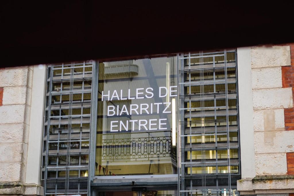 a window of a building with a sign that reads halls die bantik entrance at ALFRED HOTELS Les Halles - Ex Hotel Anjou in Biarritz