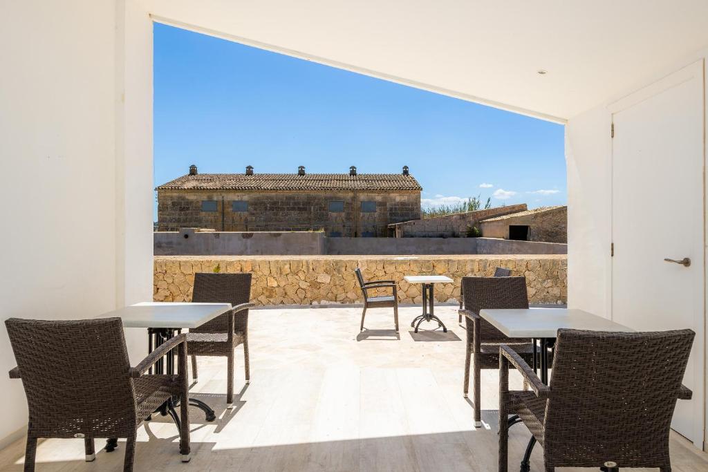 a patio with tables and chairs and a large window at Son Crespi Vell 2 in Manacor