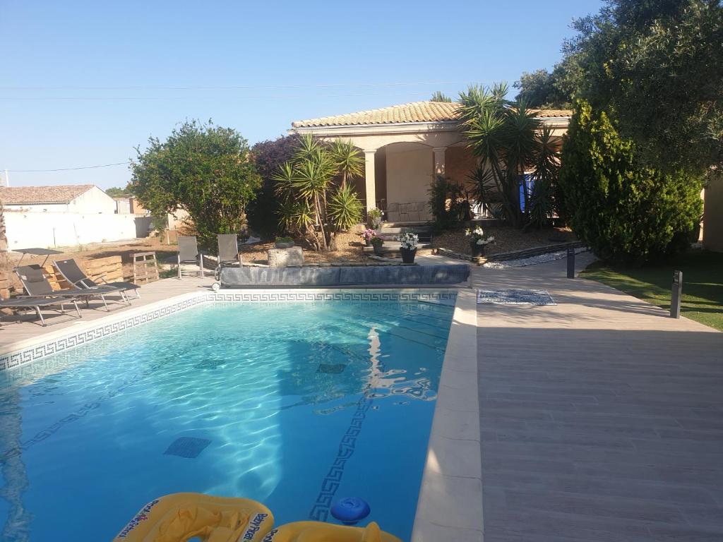 une piscine devant une maison dans l'établissement IDEAL POUR VOS VACANCES, à Espondeilhan