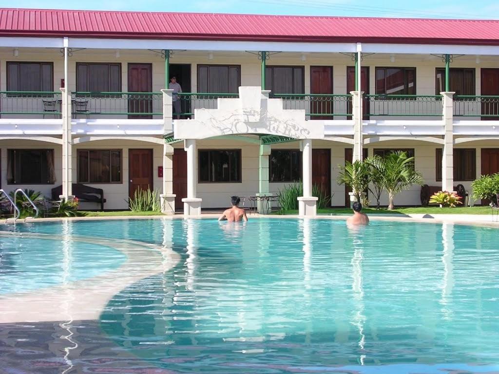 três pessoas a nadar na piscina de um hotel em Dottie's Place Hotel & Restaurant em Butuan