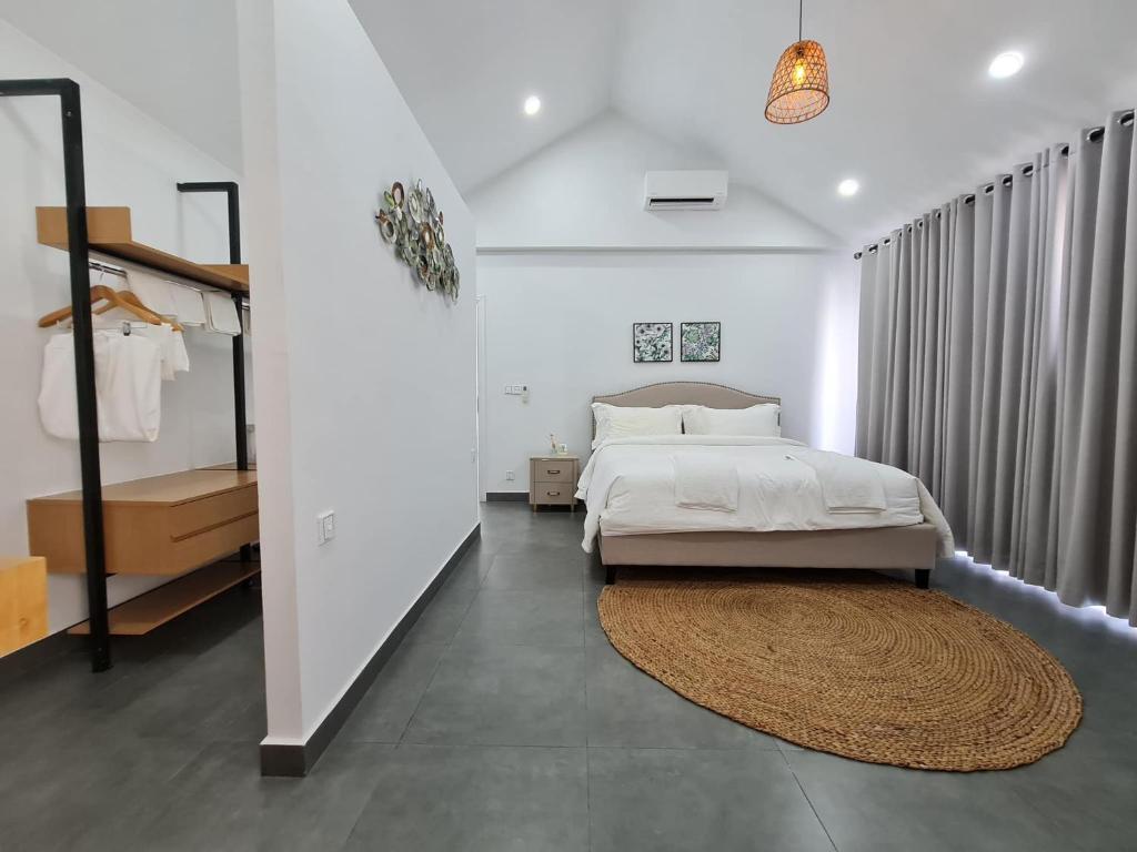 een slaapkamer met een groot bed en een tapijt bij Private Villa in Phumĭ Prêk Chrey