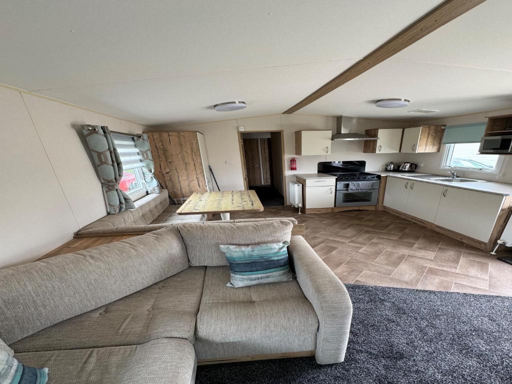 a living room with a couch and a kitchen at Captivating 3-Bed Cabin in Prestonpans in Prestonpans