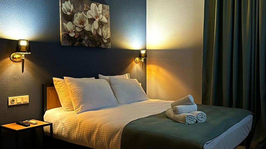een slaapkamer met een groot bed met witte kussens bij Hotel Citizen Avlabari in Tbilisi City