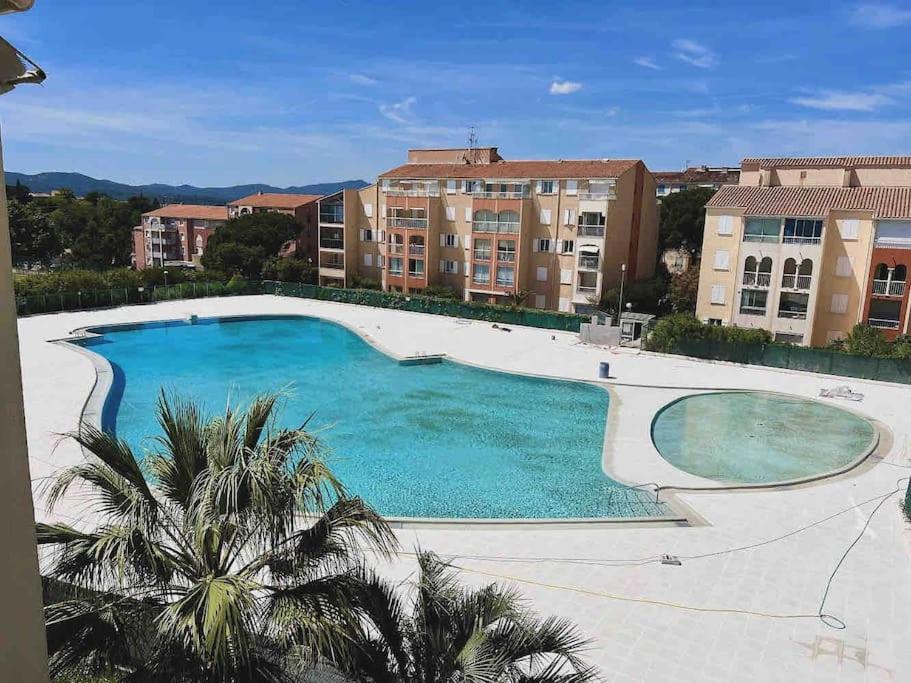 uma grande piscina em frente a alguns edifícios em Appart Lagon Bleu Piscine Tennis em Fréjus