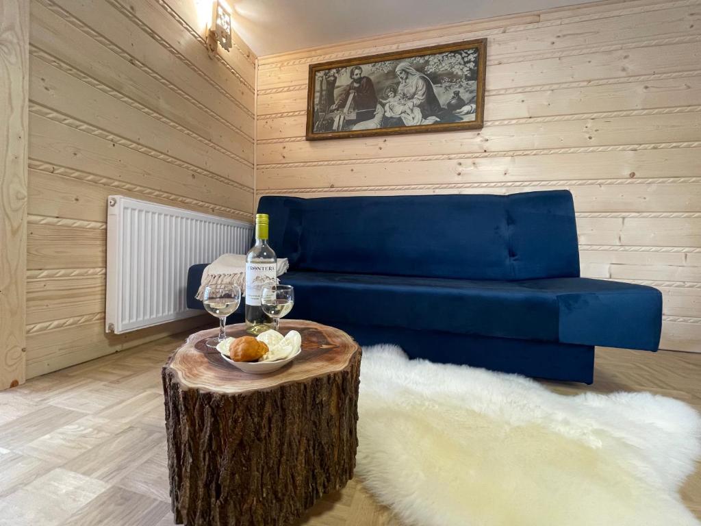 a living room with a blue couch and a tree stump coffee table at Izba na Witkówce in Nowy Targ