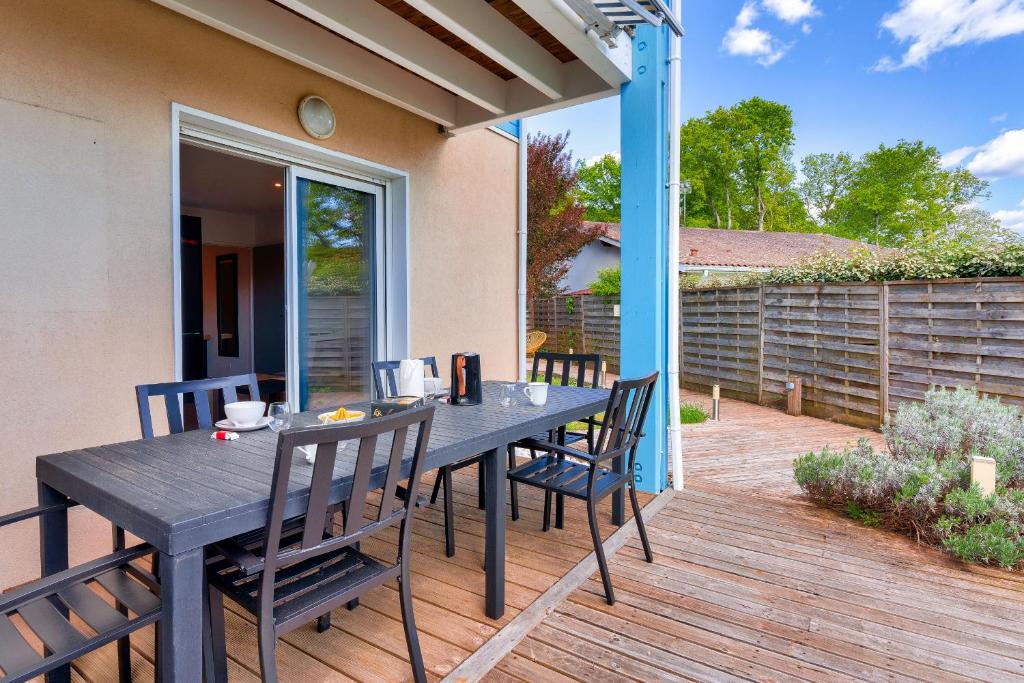 patio con tavolo e sedie su una terrazza di Sejour au coeur du Bassin d Arcachon avec jardin a Lanton