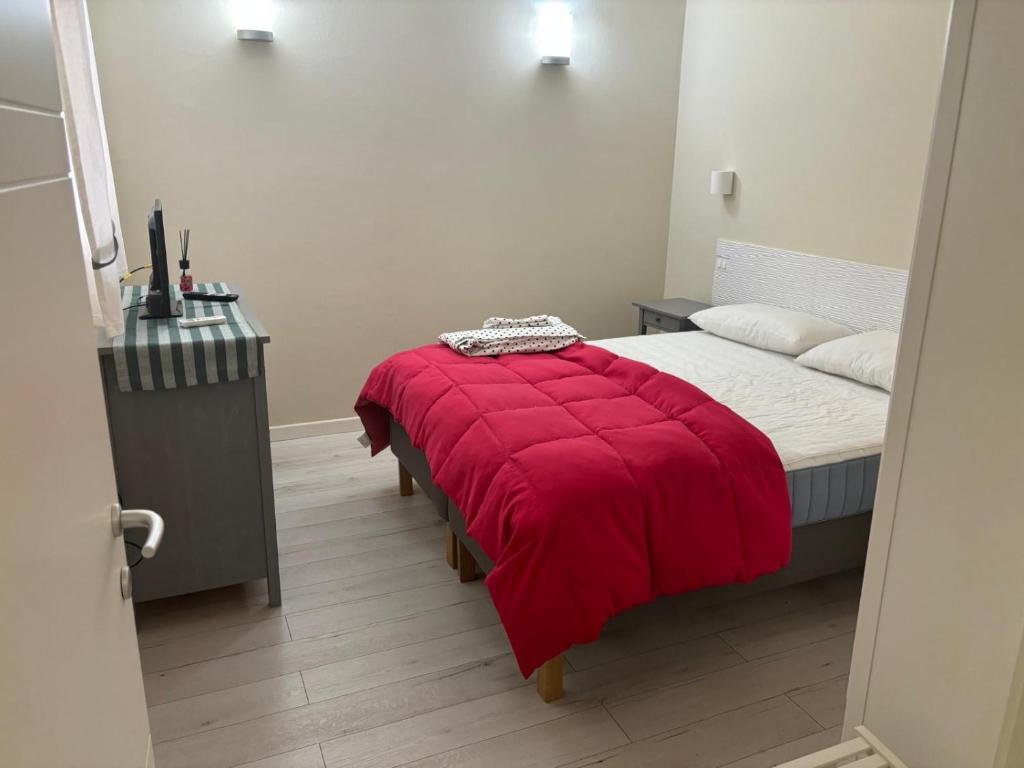a bedroom with a bed with a red blanket at Appartamento Albert in Livorno