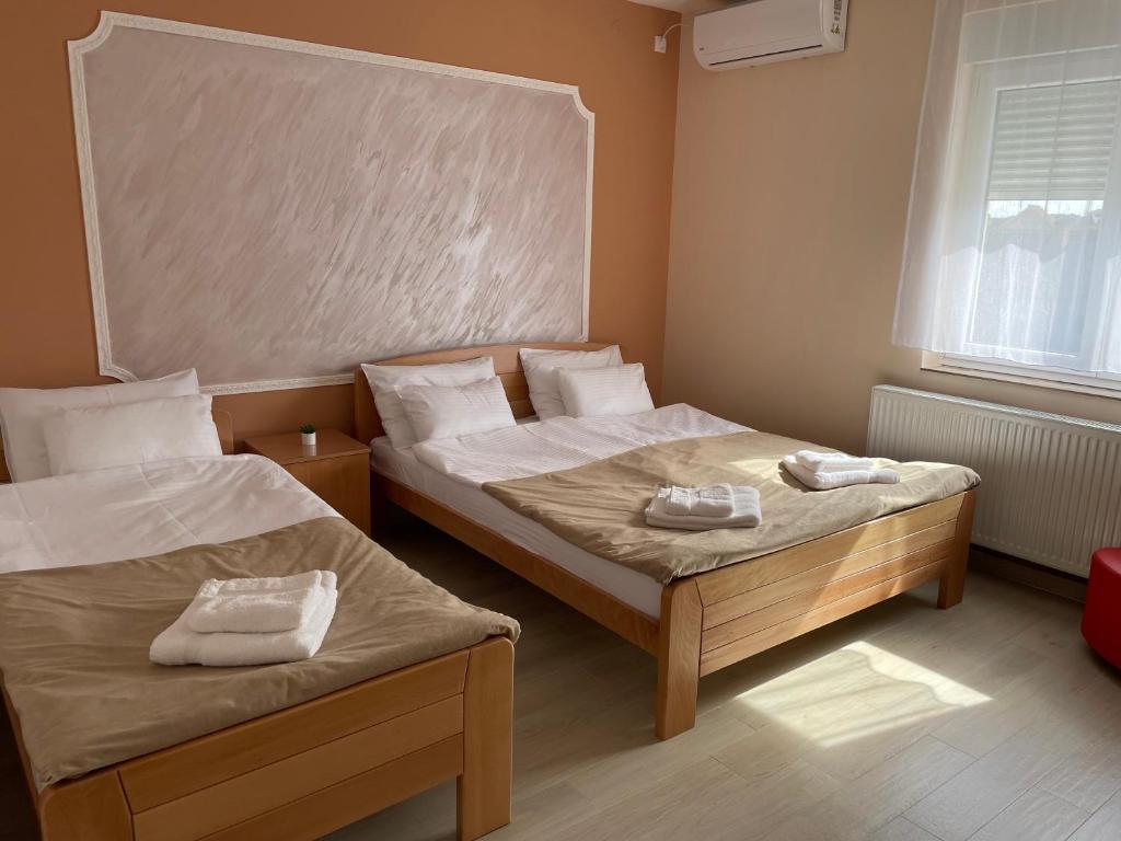 een slaapkamer met 2 bedden en handdoeken bij Sobe Sara in Šabac