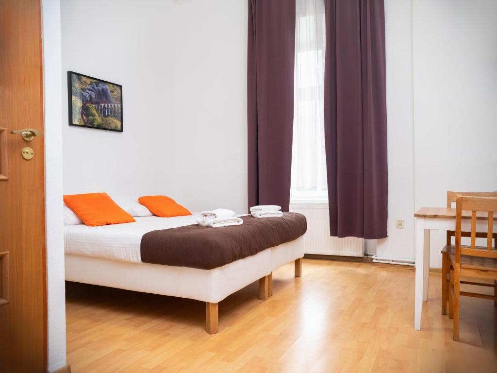 sypialnia z łóżkiem z pomarańczowymi poduszkami w obiekcie Station Aparthotel w Krakowie