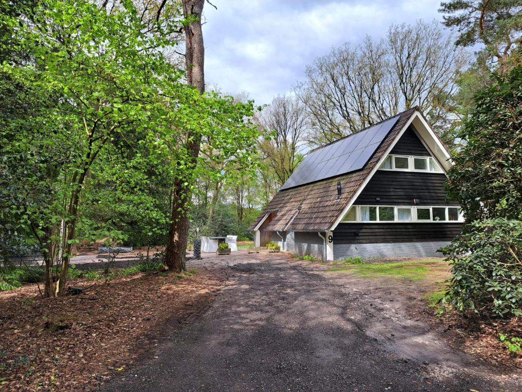 une maison avec un toit en gambrel et un chemin de terre devant dans l'établissement Natuurhuisje Meppen, à Meppen